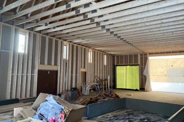 Nybygd landbruksbygg konstruksjon i Innlandet, ferdig med trebjelker og isolasjon, klare for videre oppføring og tilpasning i landbrukssektoren.