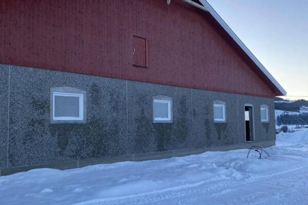 Sørlandshus under bygging på vinter i Innlandet, trehus konstruksjon, landbruksbygg, kvalitetsarbeid og tilpasset landbrukseiendom.