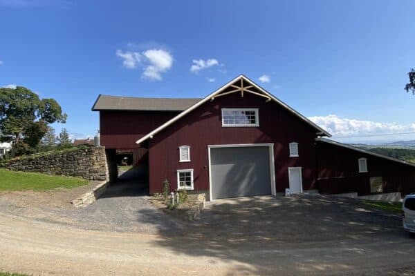 Landbruksbygg i Innlandet med tradisjonell rød farge, stor dobbel garasje, og miljøvennlig landbruksdesign, perfekt for landbruk og gårdsdrift i Innlandet Norge.